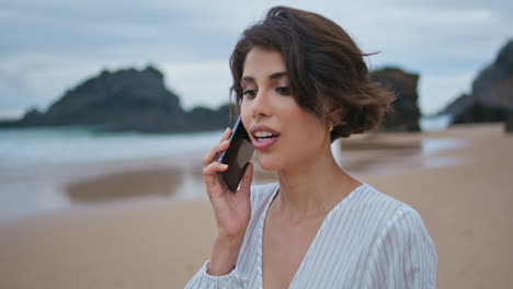 attractive woman talking mobile phone at shore closeup. beach lady making call