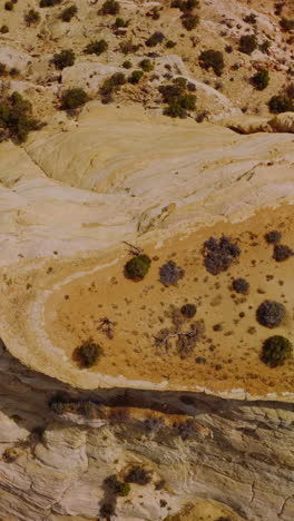 dry and lifeless landscape of deserted territories in national park of utah, usa. circle drone footage over the rock lit with bright hot sun. vertical video