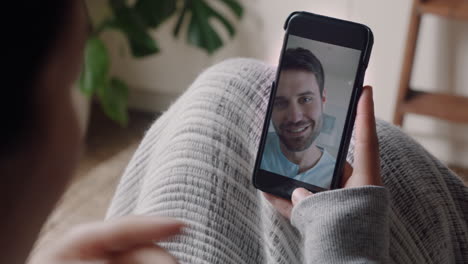 Mujer-Joven-Teniendo-Video-Chat-Usando-Un-Teléfono-Inteligente-En-Casa-Charlando-Con-Su-Novio-Lanzando-Un-Beso-Disfrutando-De-Una-Conversación-Compartiendo-Su-Estilo-De-Vida-Comunicándose-Con-Un-Teléfono-Móvil