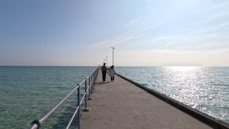 couple strolling on a sunny pier