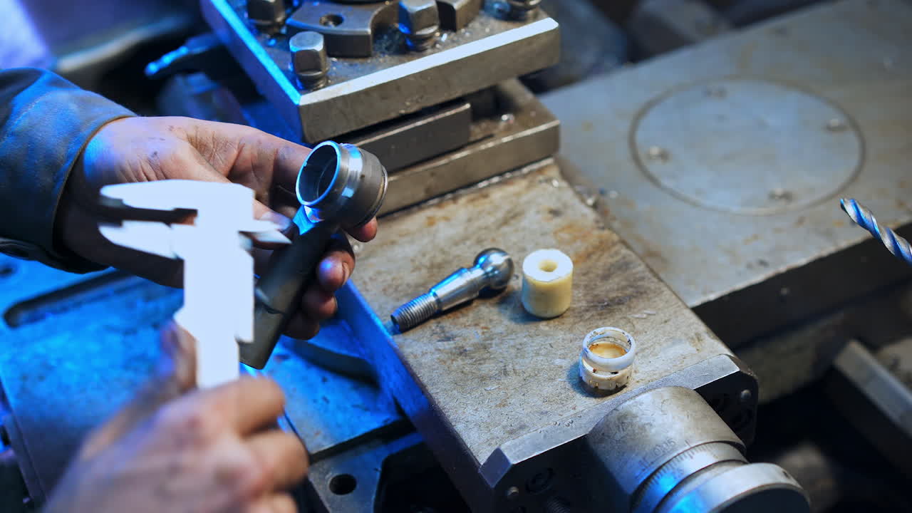 Technician inspecting metal parts on a machine