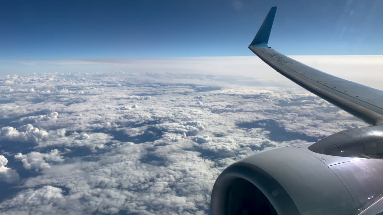 un velo de nubes blancas y esponjosas vista desde la ventana de un avión volador