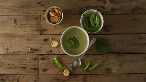 video of green peas soup and ingredients lying on wooden surface