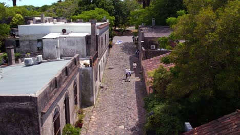 Aerial-View-Of-People-On-Calle-de-los-Suspiros---Historical-Street-In-Colonia-del-Sacramento-In-Uruguay