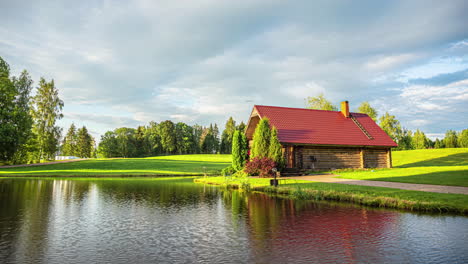 timelapse of a sunset in the countryside with a lake and a log cabin