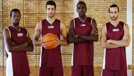 jugadores de baloncesto confiados sosteniendo el baloncesto en la cancha