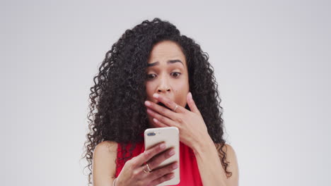 una mujer reaccionando a un mensaje en su teléfono.