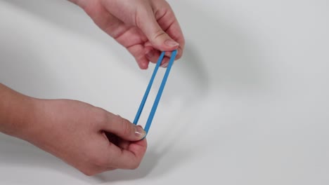 hands pulling and stretching a blue hair tie