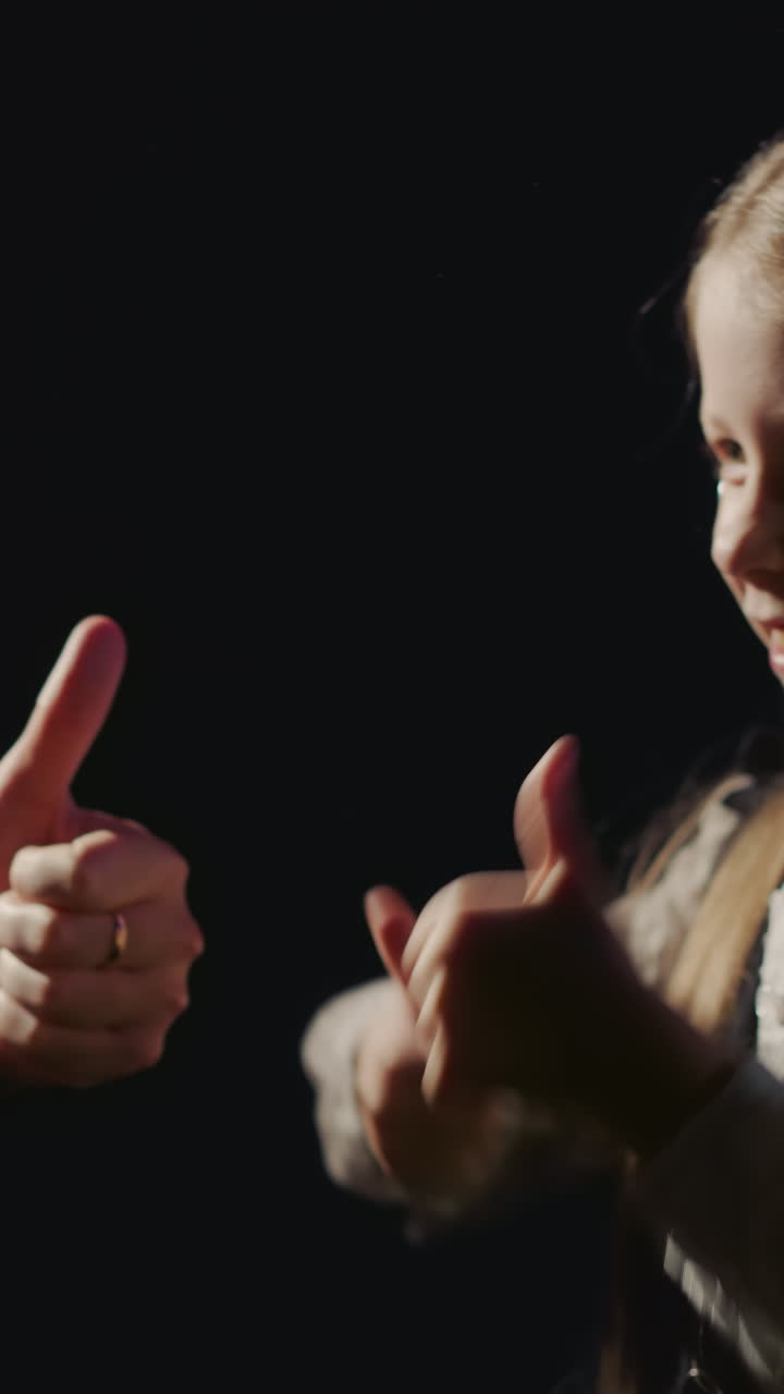 niño y director de sonido muestran pulgares en el estudio de audio. padre feliz con hija pequeña trabajan juntos en el primer sencillo de música en la habitación. joven vocalista