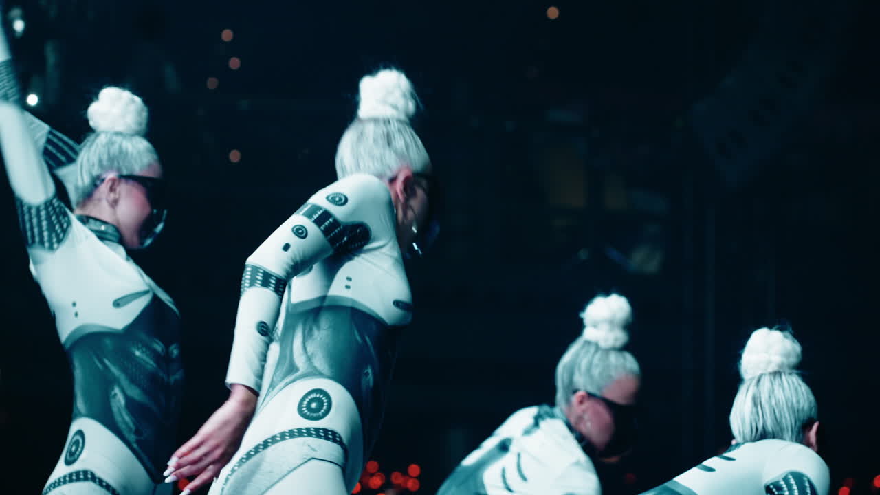 grupo de mujeres con trajes futuristas actuando en el escenario