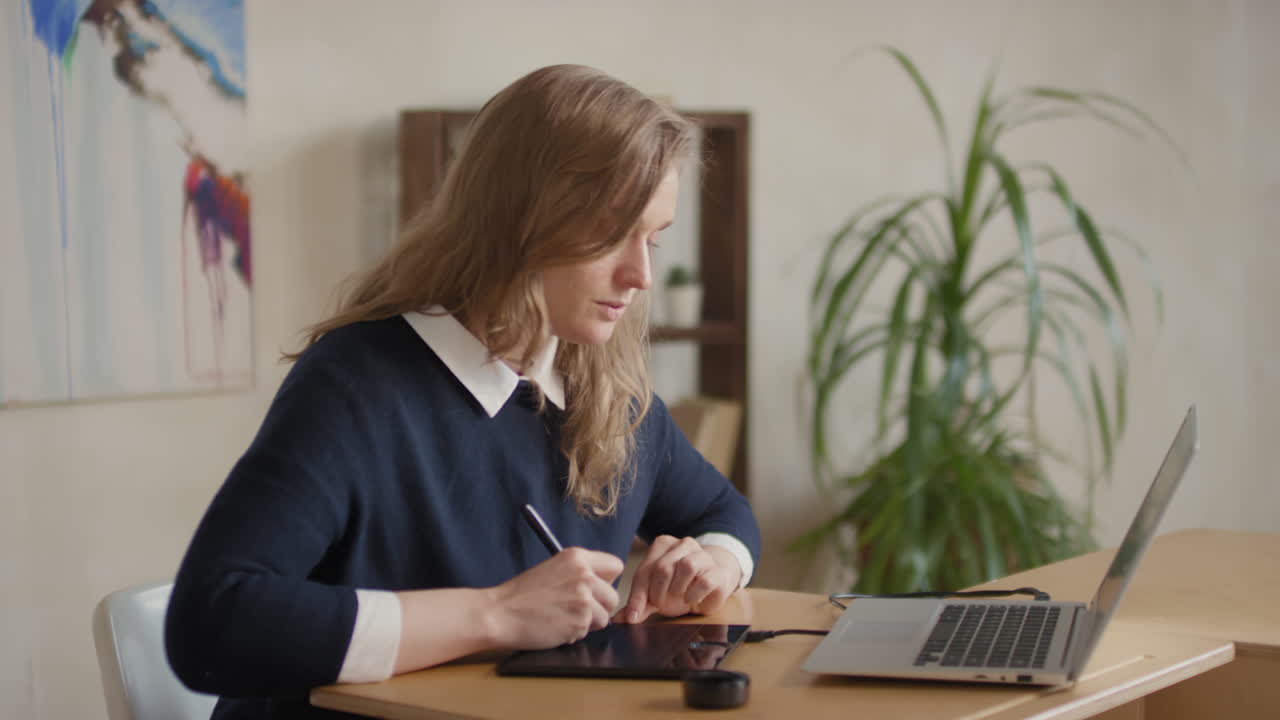 Kvinde bruger en tegnetablet og bærbar computer