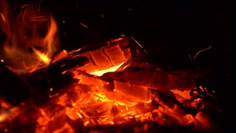 a long metal poker stirs the glowing embers in the stove.