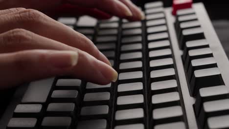 fingers typing on grey mechanical keyboard of computer, close up aside shot