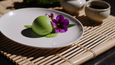 elegant green dessert with purple flower on bamboo mat