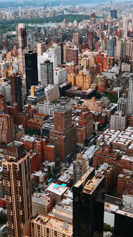 flight over the tops of skyscrapers and multistoried buildings. beautiful lush greenery of central park at backdrop. top view.