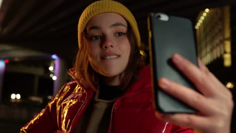 mujer enfocada tomando una selfie en el teléfono inteligente. chica posando para la cámara del teléfono al aire libre.