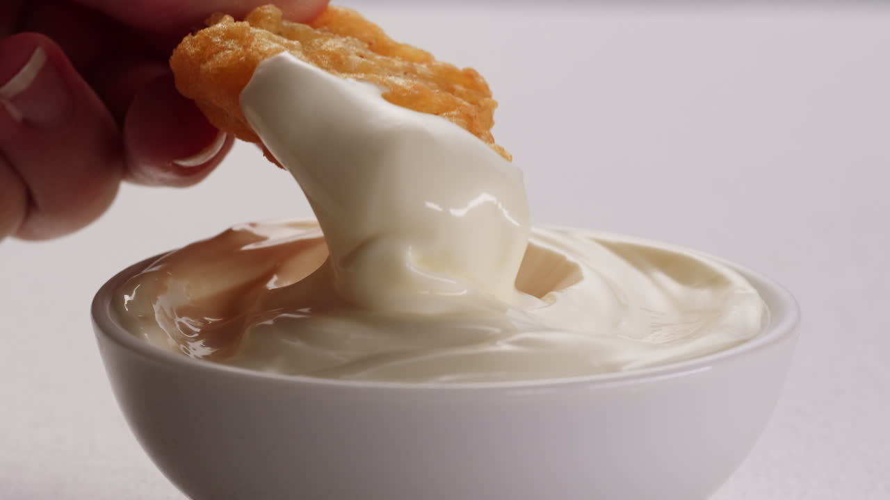 sumergiendo nuggets de pollo en mayo