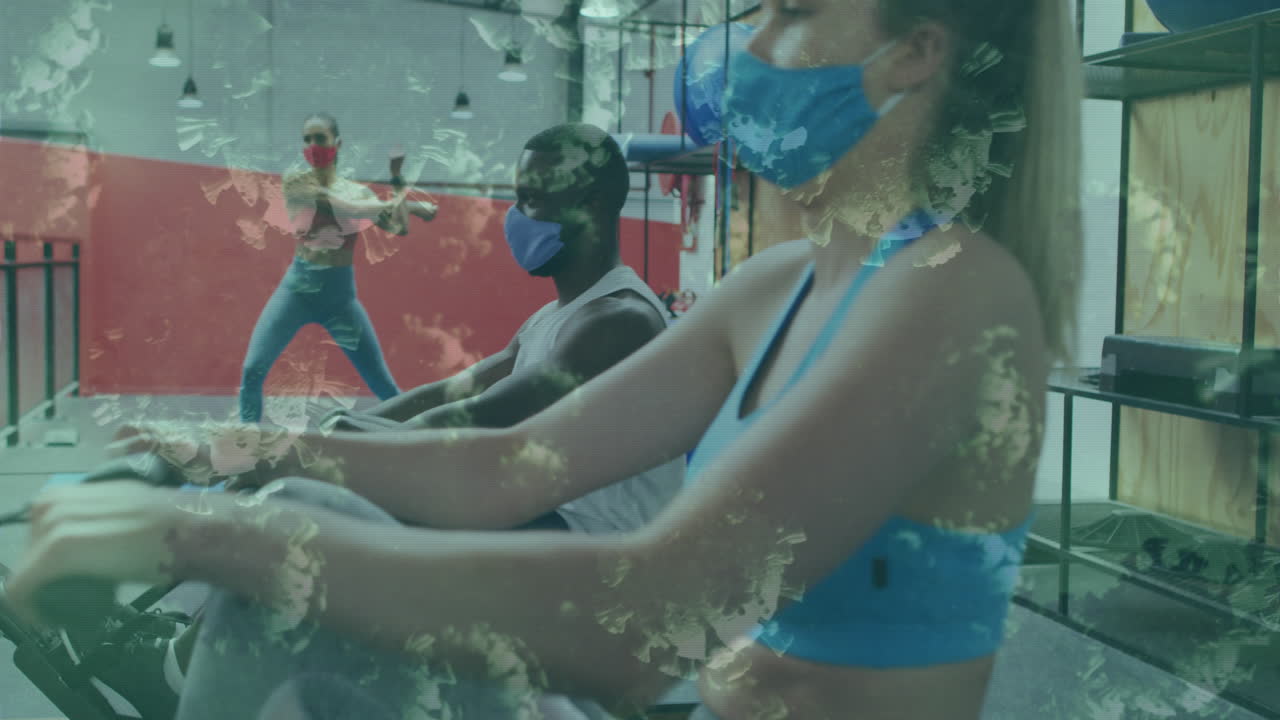 코로나19 세포가 마스크를 쓰고 체육관에서 로잉 운동을 하는 남자와 여자를 향해 떠다니고 있습니다.