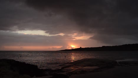 early morning in qawra, malta, before sunrise, rainy stormy clouds