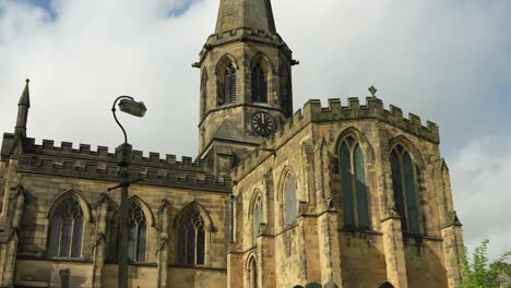 old church of england with graveyard, in peak district town, rural britain, in 4k, 60fps slow motion