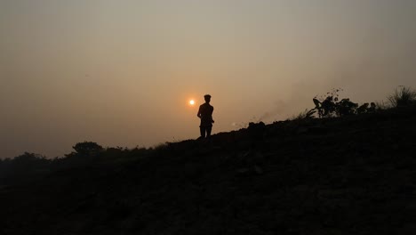 wide establisher cinematic shot of man running on rural scene, silhouette