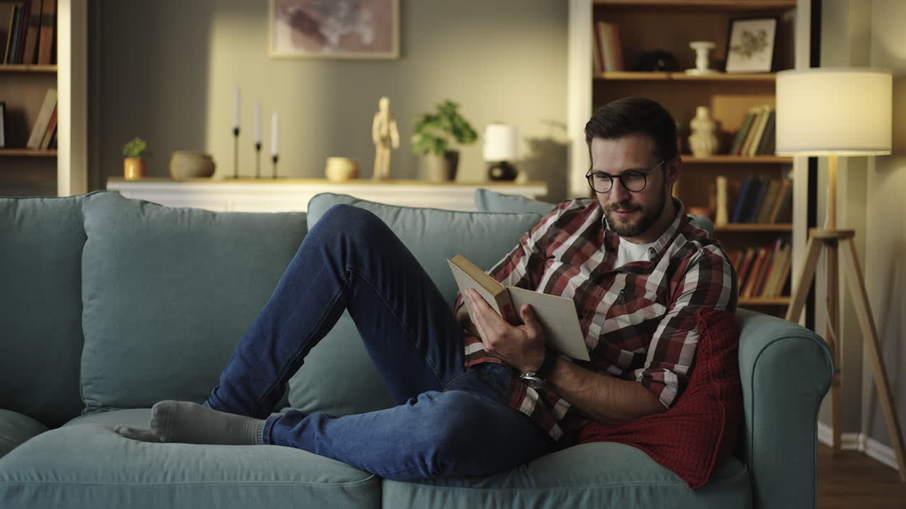 Man reading a book on the couch