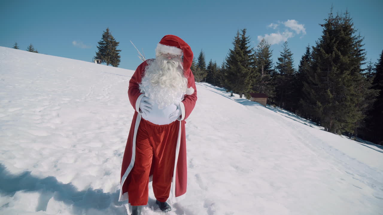 santa camina hacia la cámara a través de un campo nevado