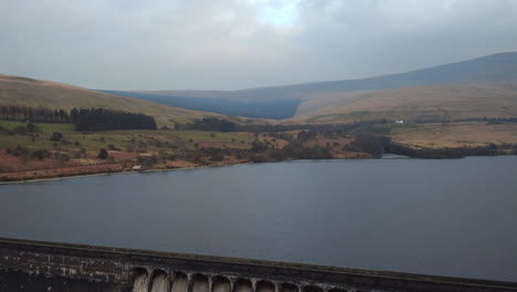 dramatic aerial shot reversing to reveal a huge dam