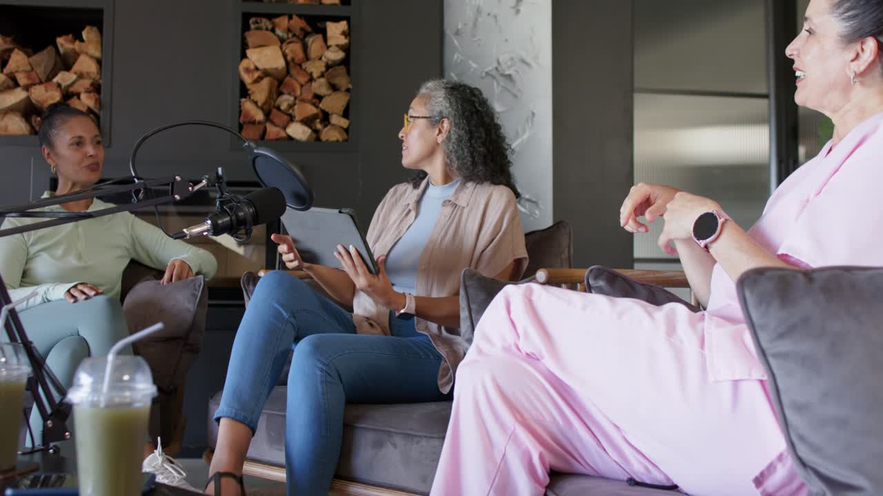Diverse female hosts reacting to left laugh, moderating, adjusting mic and reading tablet in lounge