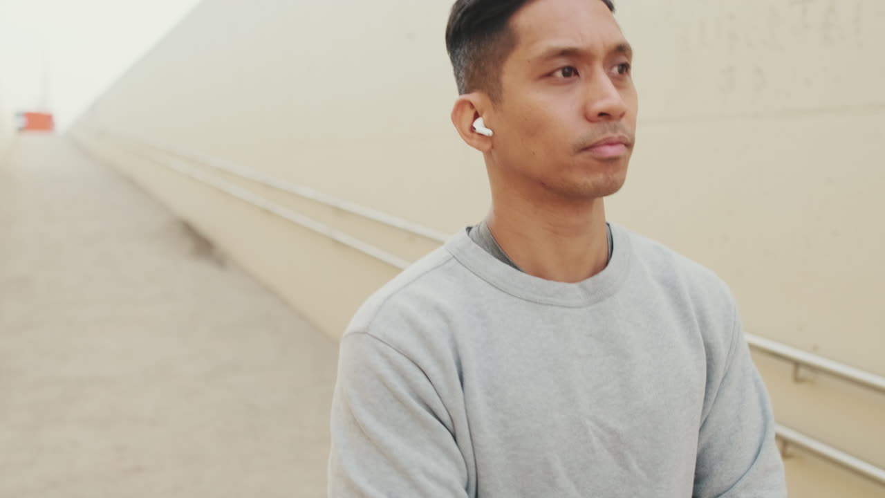 A man wearing earbuds in a tunnel
