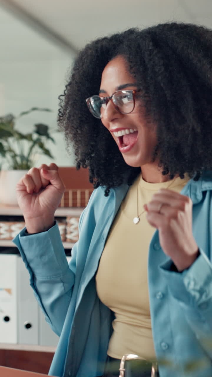 Giovane donna felice che applaude e celebra il successo in ufficio