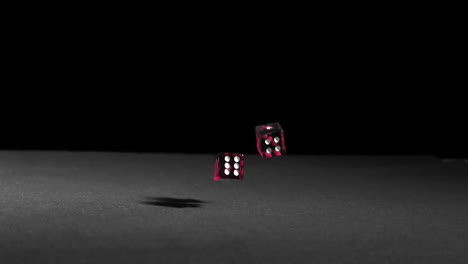 pink dice falling on black table