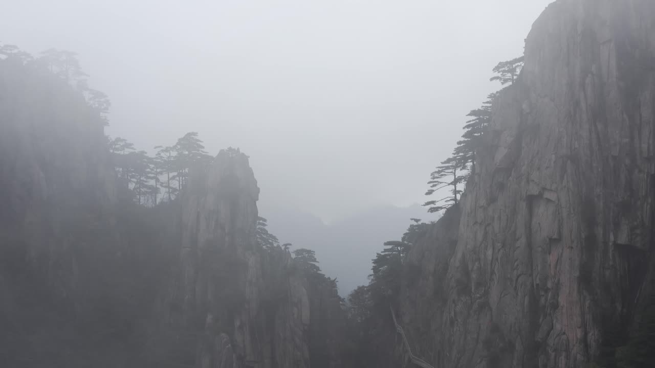 Amazing low aerial flight through cloudy Mountain peak ridge, Yellow Mountain in Huangshan China