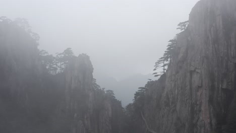 amazing low aerial flight through cloudy mountain peak ridge, yellow mountain in huangshan china