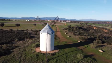 antena acercándose al tradicional molino de viento blanco hierba verde y luz dorada