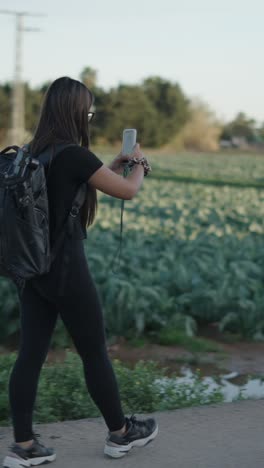 woman walking outdoors with camera backpack