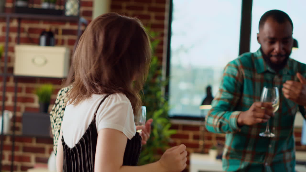 Group of friends dancing at apartment party, celebrating their friendship