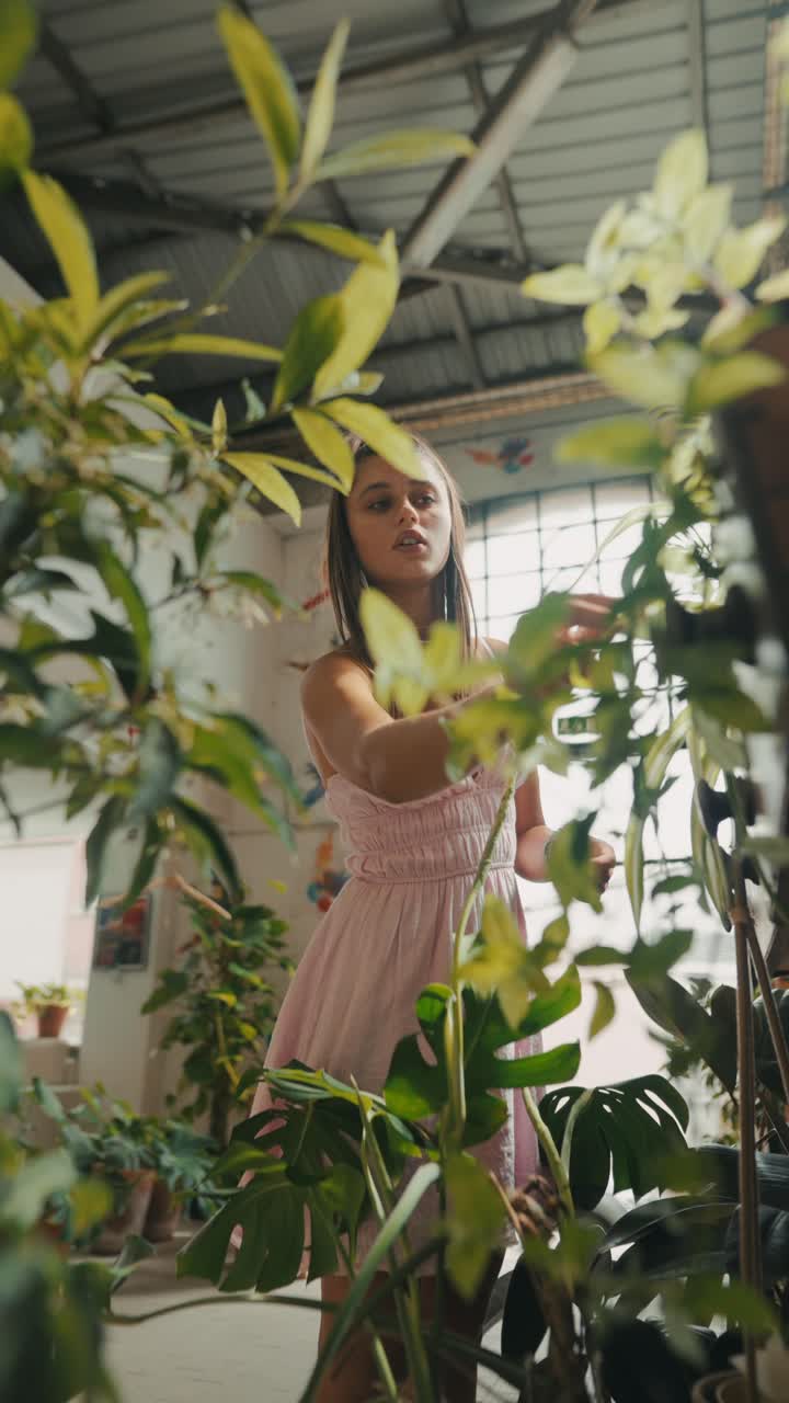 A woman in a pink dress surrounded by plants