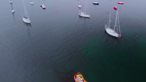 aerial view of a lake with colorful boats near the snowy city