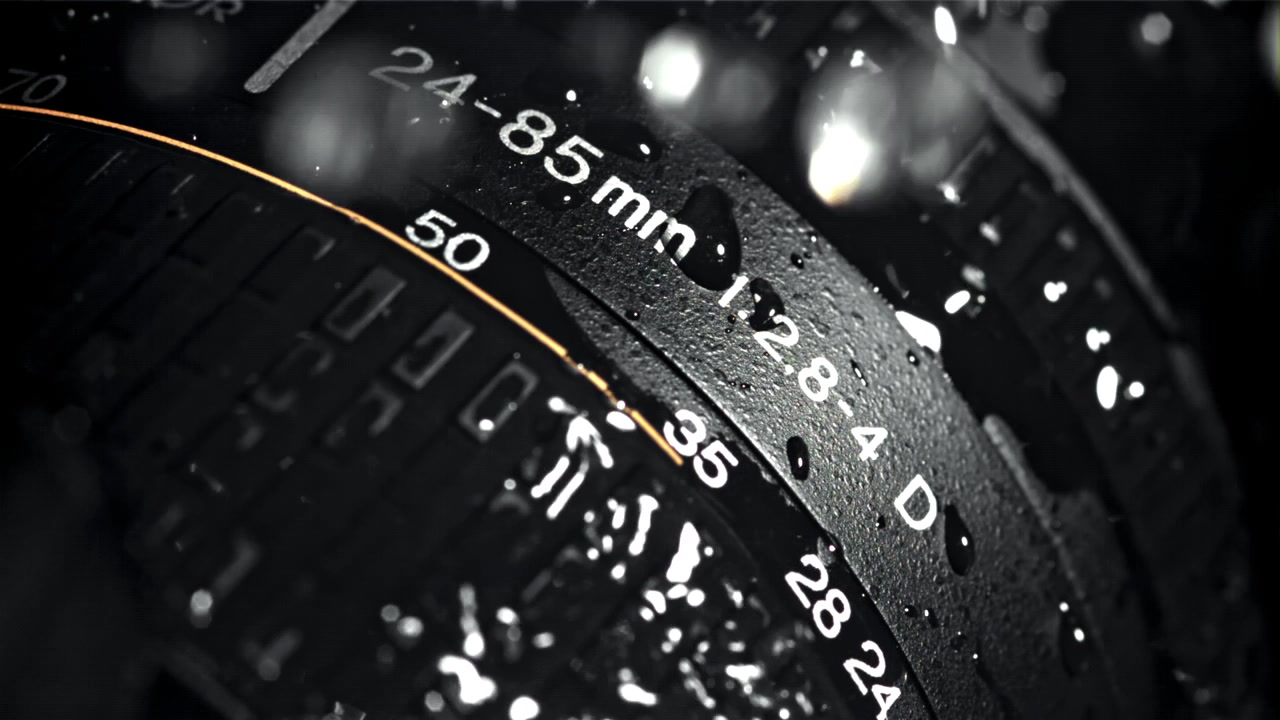 Macro Shot of Water Droplets Splashing on a Camera Lens