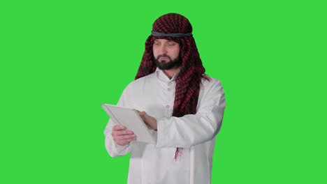 sheikh presenting information or product using digital tablet on a green screen, chroma key