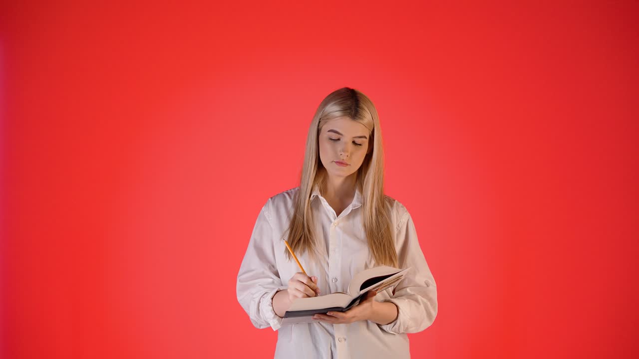 Young Woman Studying and Writing in a Book