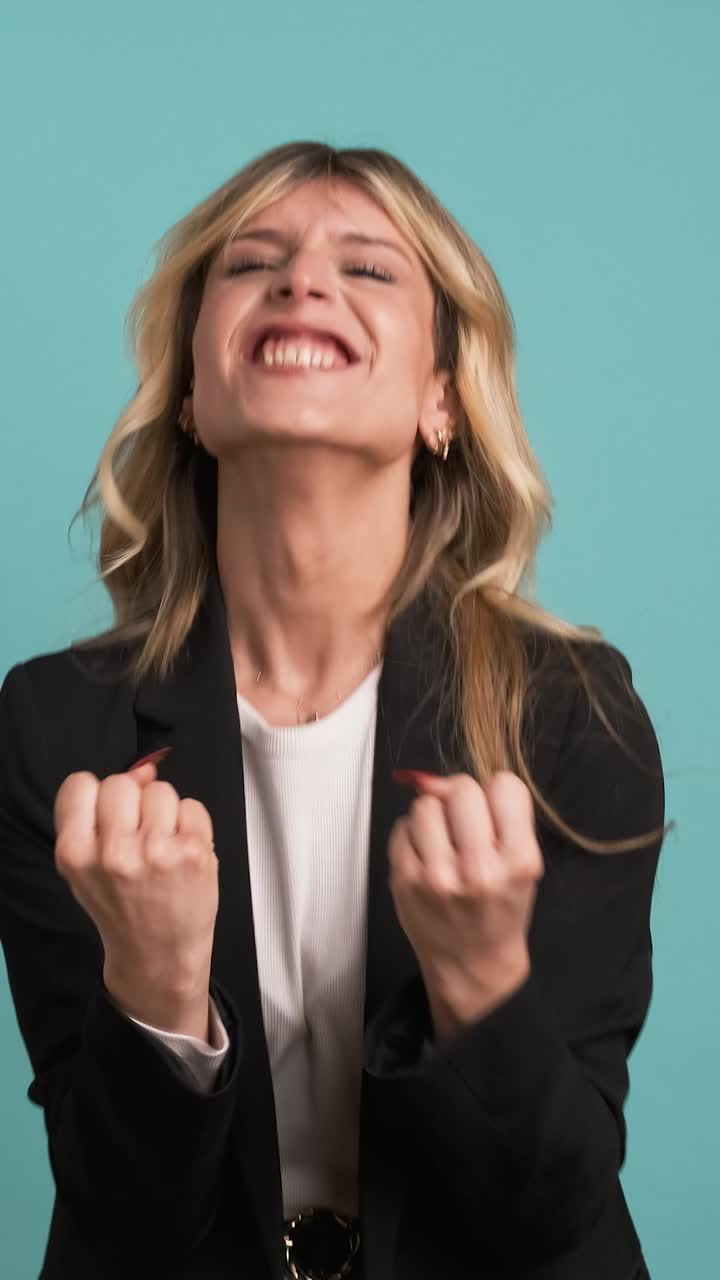 Successful transgender businesswoman screaming as she celebrates victory on blue background