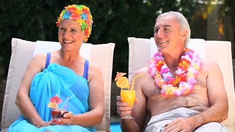 Old-man-and-woman-relaxing-near-the-pool.