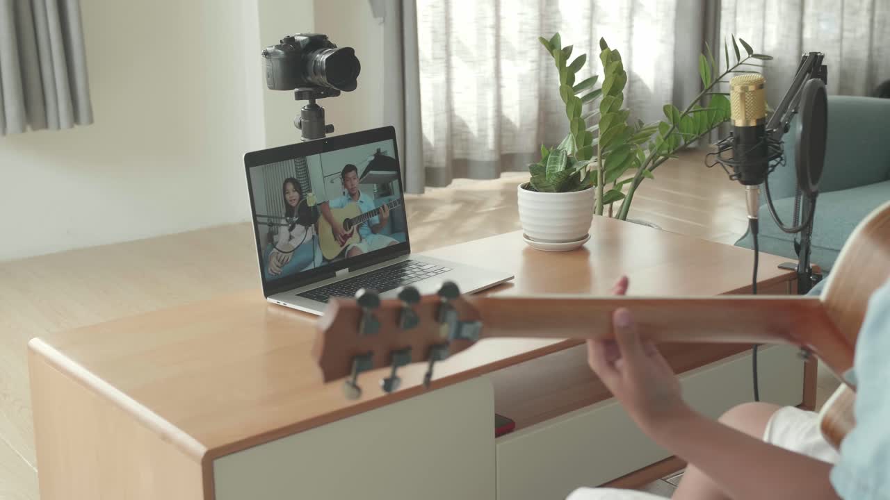 Person Playing Guitar During Video Call with Friends
