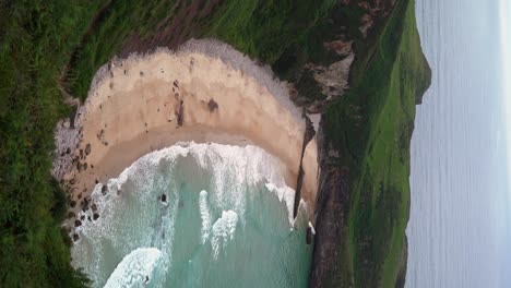 Wellen,-Die-Am-Strand-Von-Ballota-In-Spanien-An-Land-Spülen,-Vertikale-Landschaft