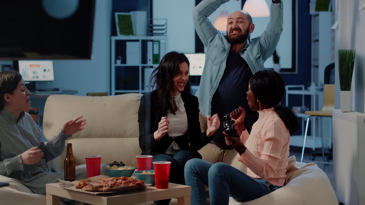 Multi ethnic workmates winning video games on console