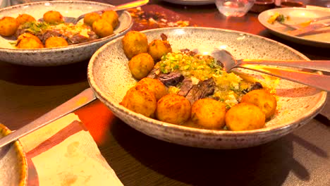 close up in slow motion, of the plate with a piece of steak and potatoes in a very well prepared lisbon type ball