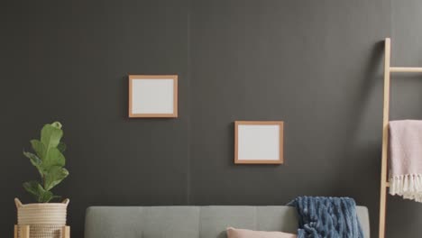 marcos de madera con espacio de copia en fondo blanco con planta y sofá contra la pared gris