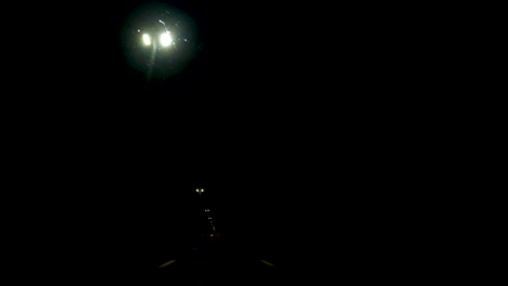 Punto-De-Vista-De-Un-Conductor-Conduciendo-Por-Una-Carretera-En-Una-Noche-Oscura